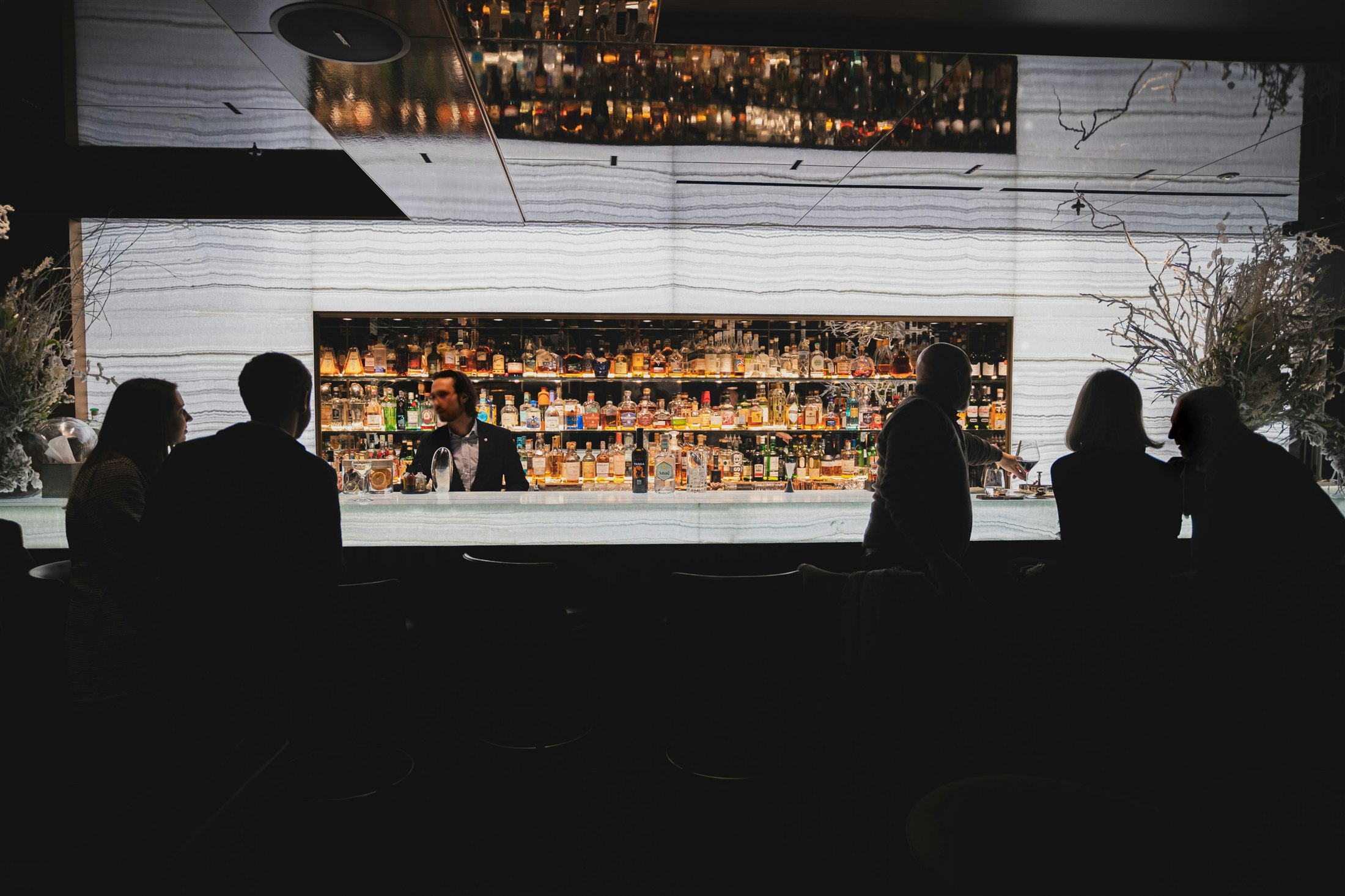 People gathering at a dramatically lit bar